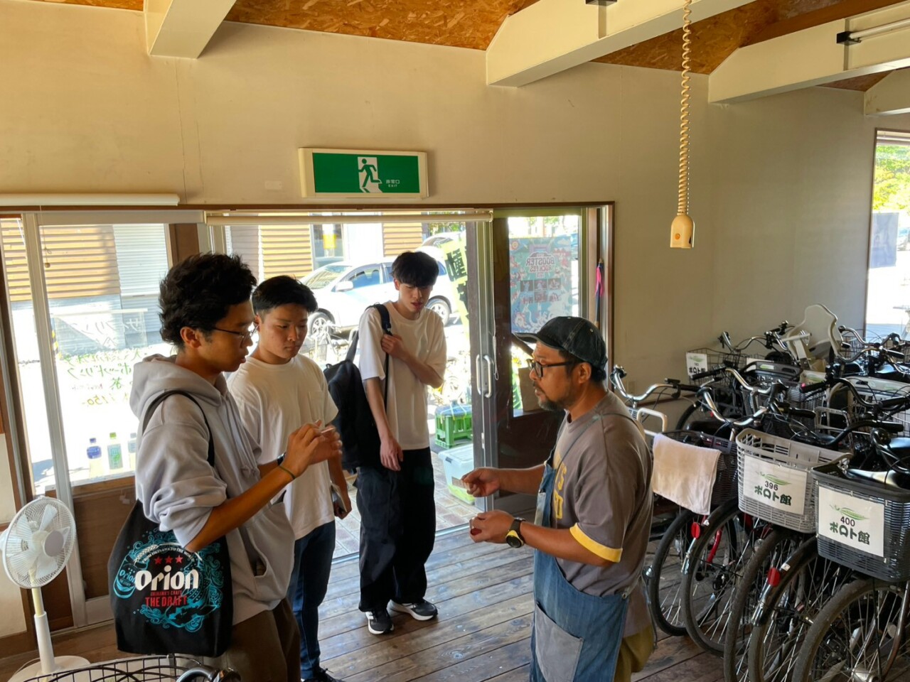 レンタルサイクル森商店で、自転車を利用する観光客の動きについて話を聞く千葉商科大学の学生たち